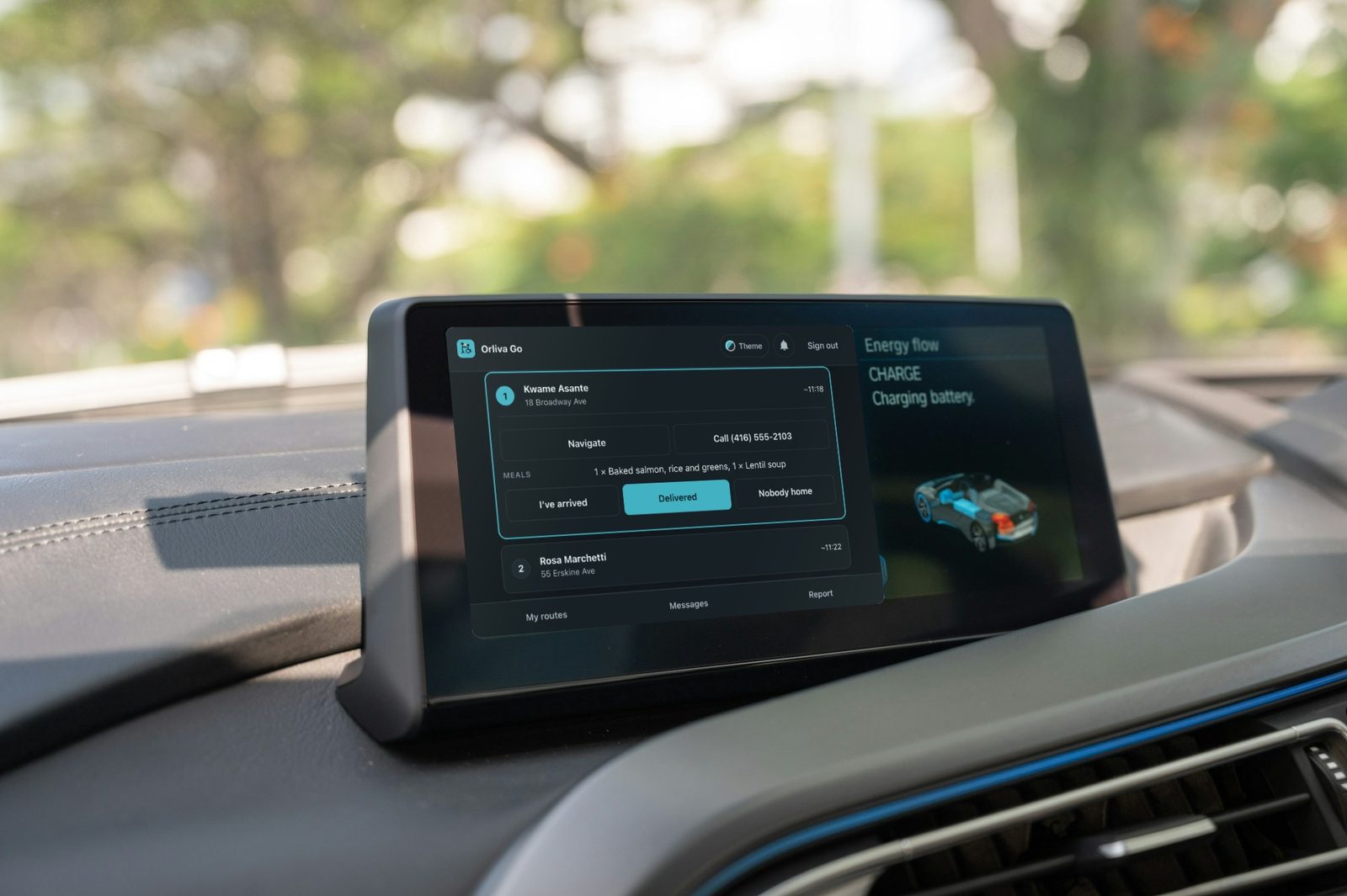 A car dashboard screen showing Orliva Go on a meal route: the next stop, the meals to drop off, and buttons for arrived and delivered.