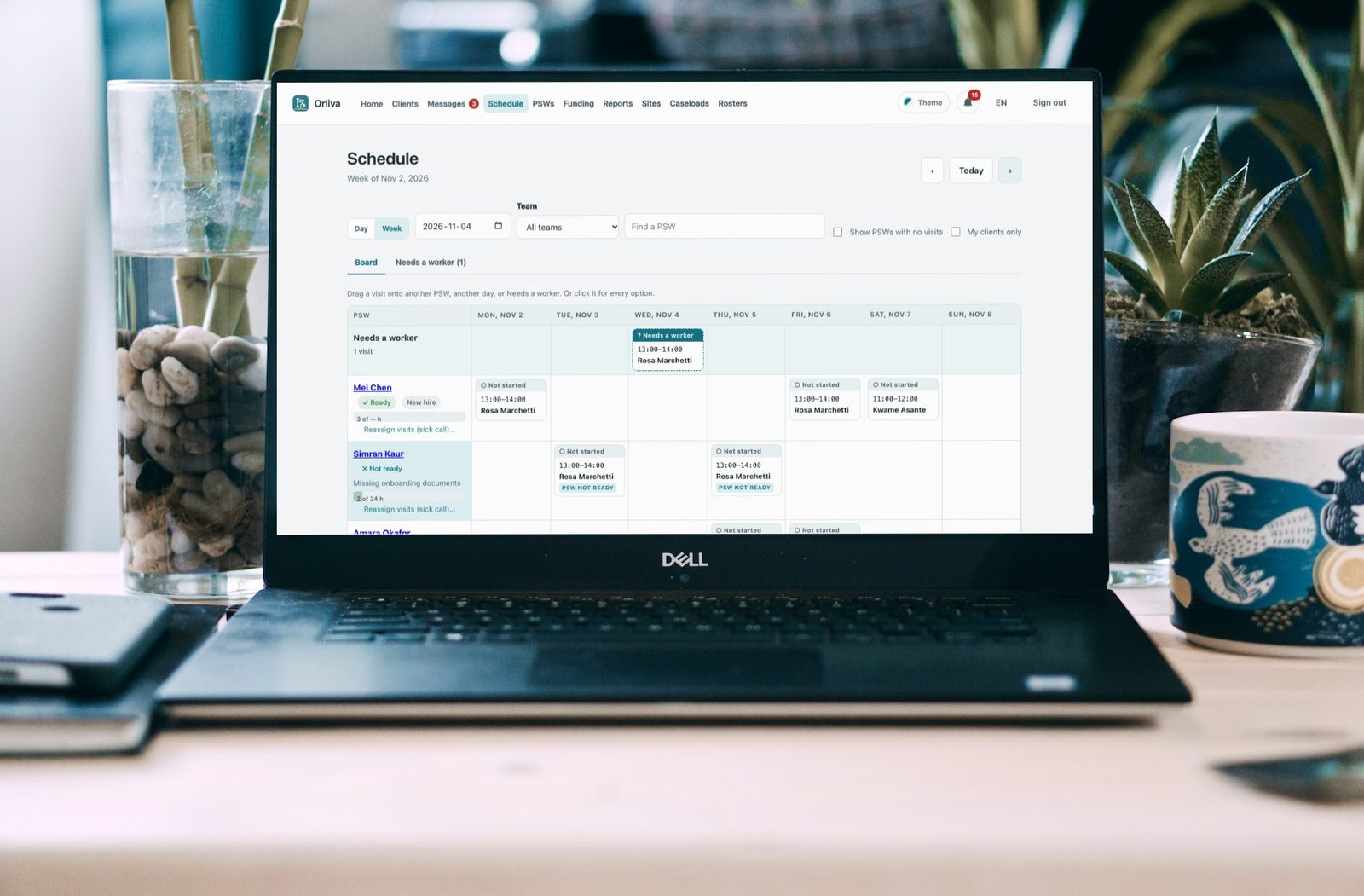 A laptop on an office desk showing the Orliva schedule: a week of visits for each PSW, with one visit waiting for a worker.